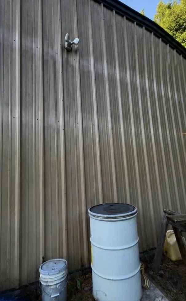 Metal siding coated in dark grime before cleaning